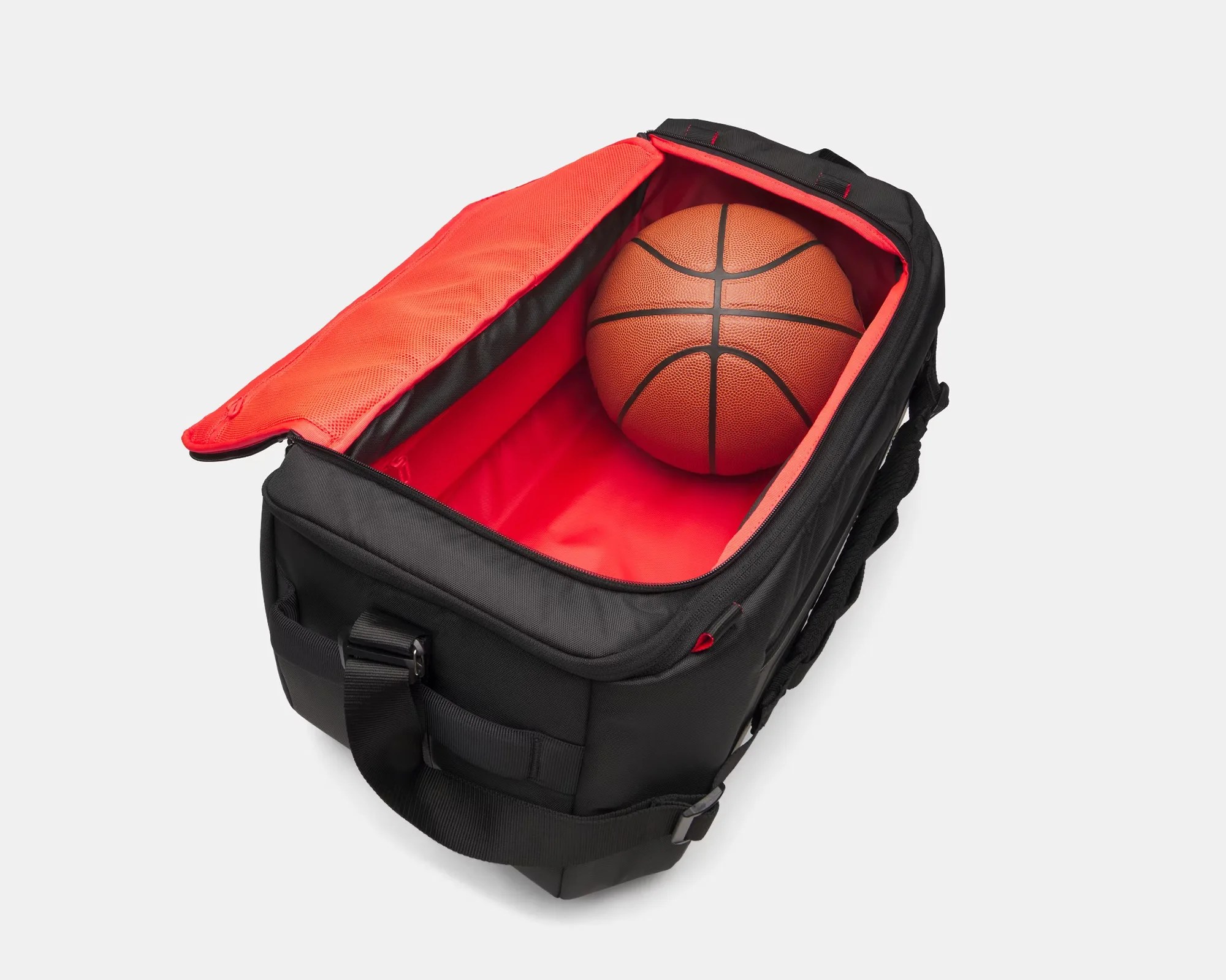 Black duffel bag with red interior lining holding a basketball inside.
