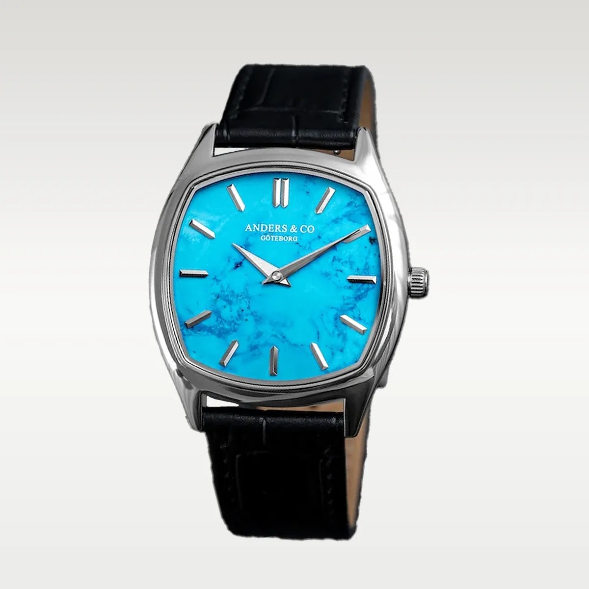 Silver wristwatch with a bright turquoise marbled dial and black leather strap.
