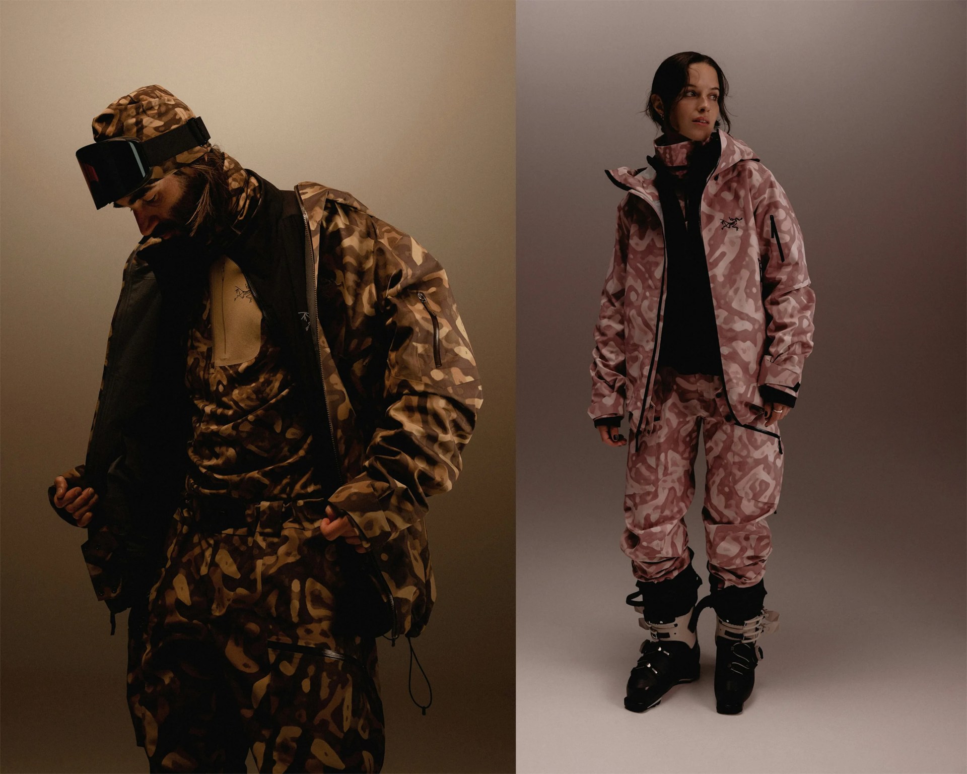 Two people wearing camo-patterned ski outfits, one in brown and the other in pink, with jackets, pants, and ski boots.