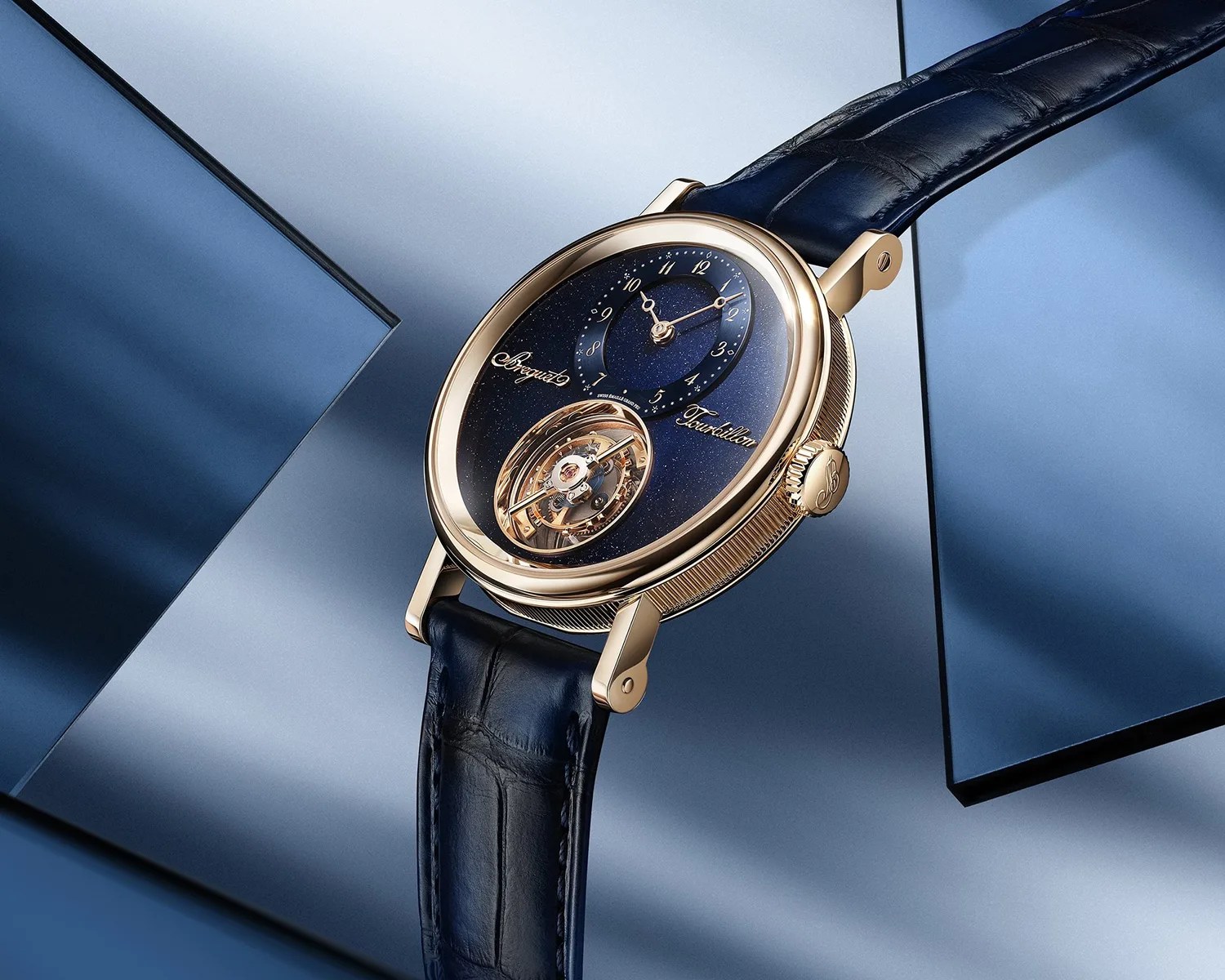 Gold wristwatch with a blue starry dial, visible tourbillon, and dark blue leather strap on a blue geometric background.