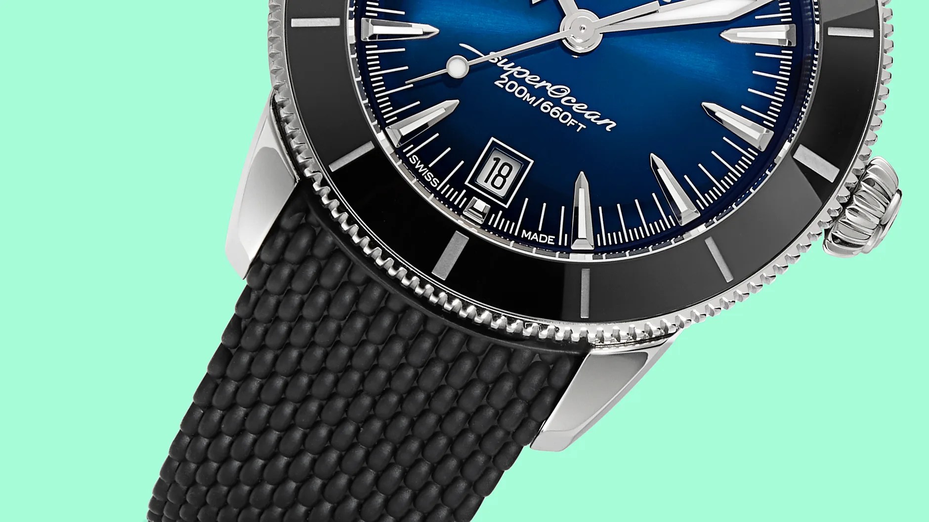 Close-up of a blue dial SuperOcean watch with black bezel and textured black rubber strap.