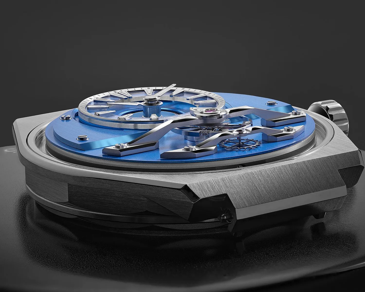 Close-up of a mechanical watch movement with blue base plate and silver gears in a brushed metal case.