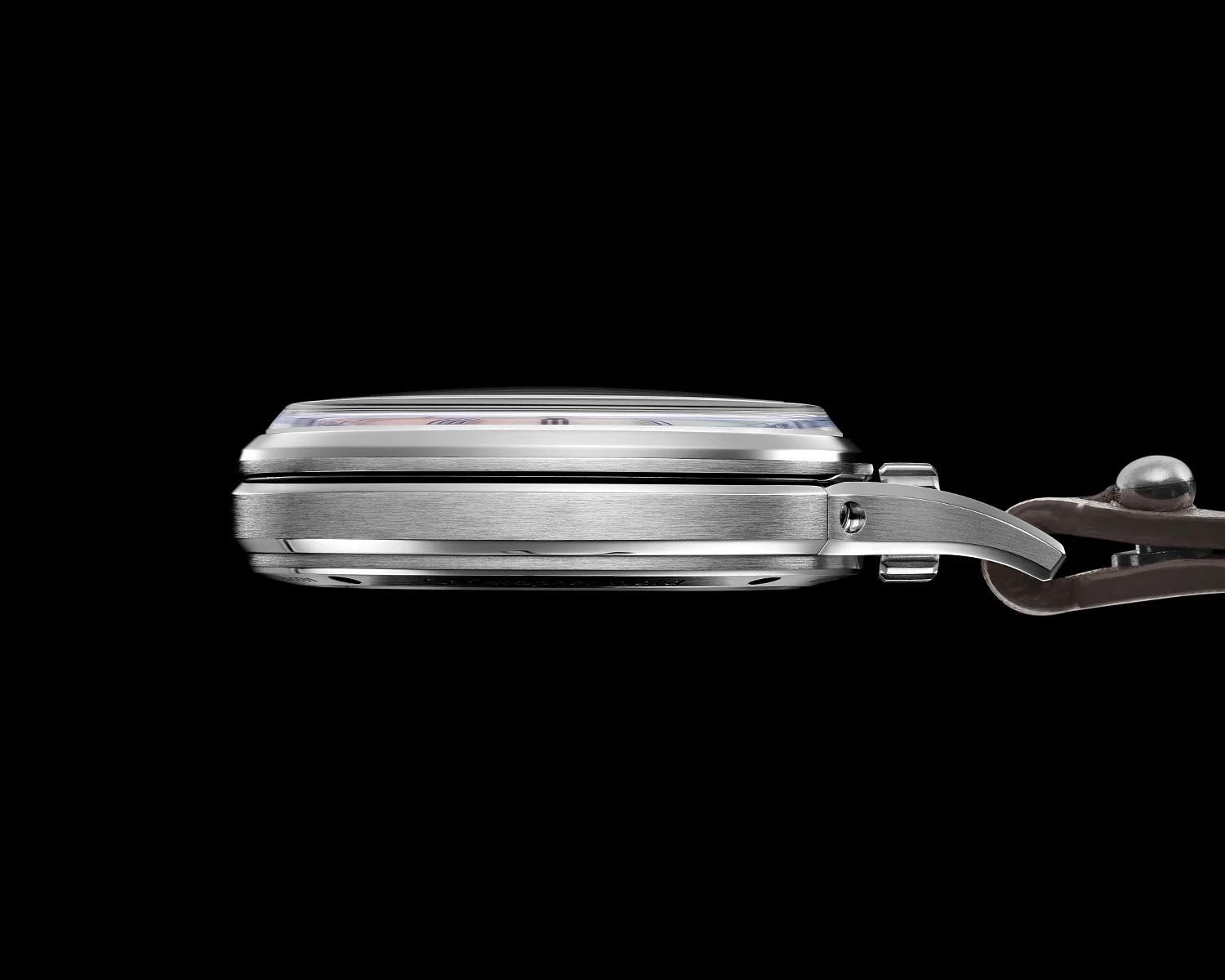 Side profile of a silver metal watch case with a domed crystal and attached brown leather strap.