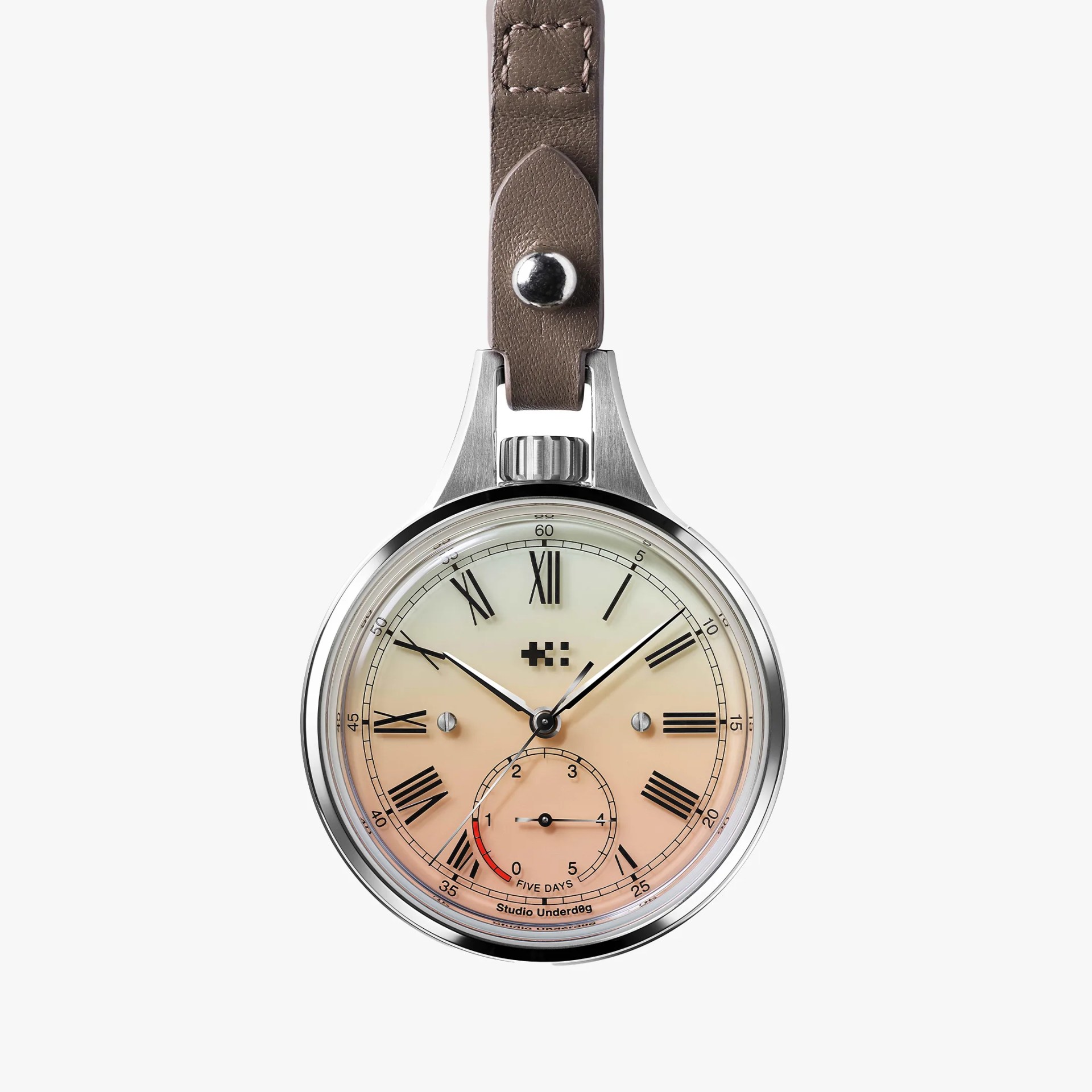 Round silver pocket watch with gradient cream to peach dial, black Roman numerals, and taupe leather strap.