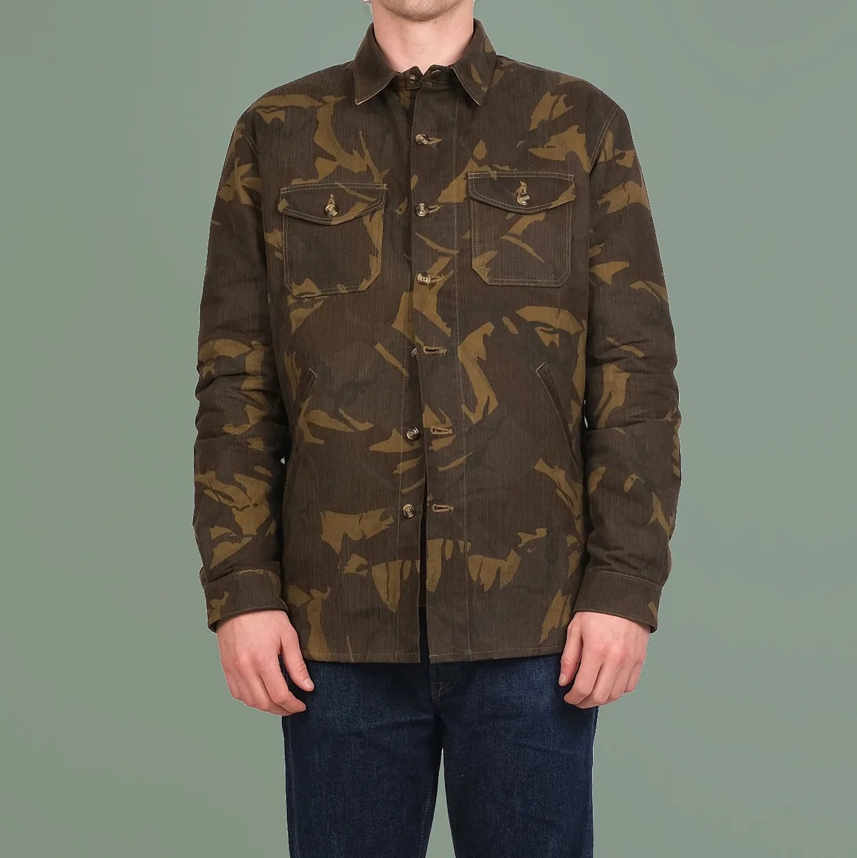 Brown and olive camouflage button-up jacket with chest flap pockets worn by a person.