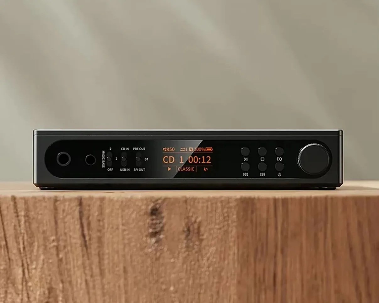 Black audio player with digital display showing CD track info and multiple control buttons on a wooden surface.