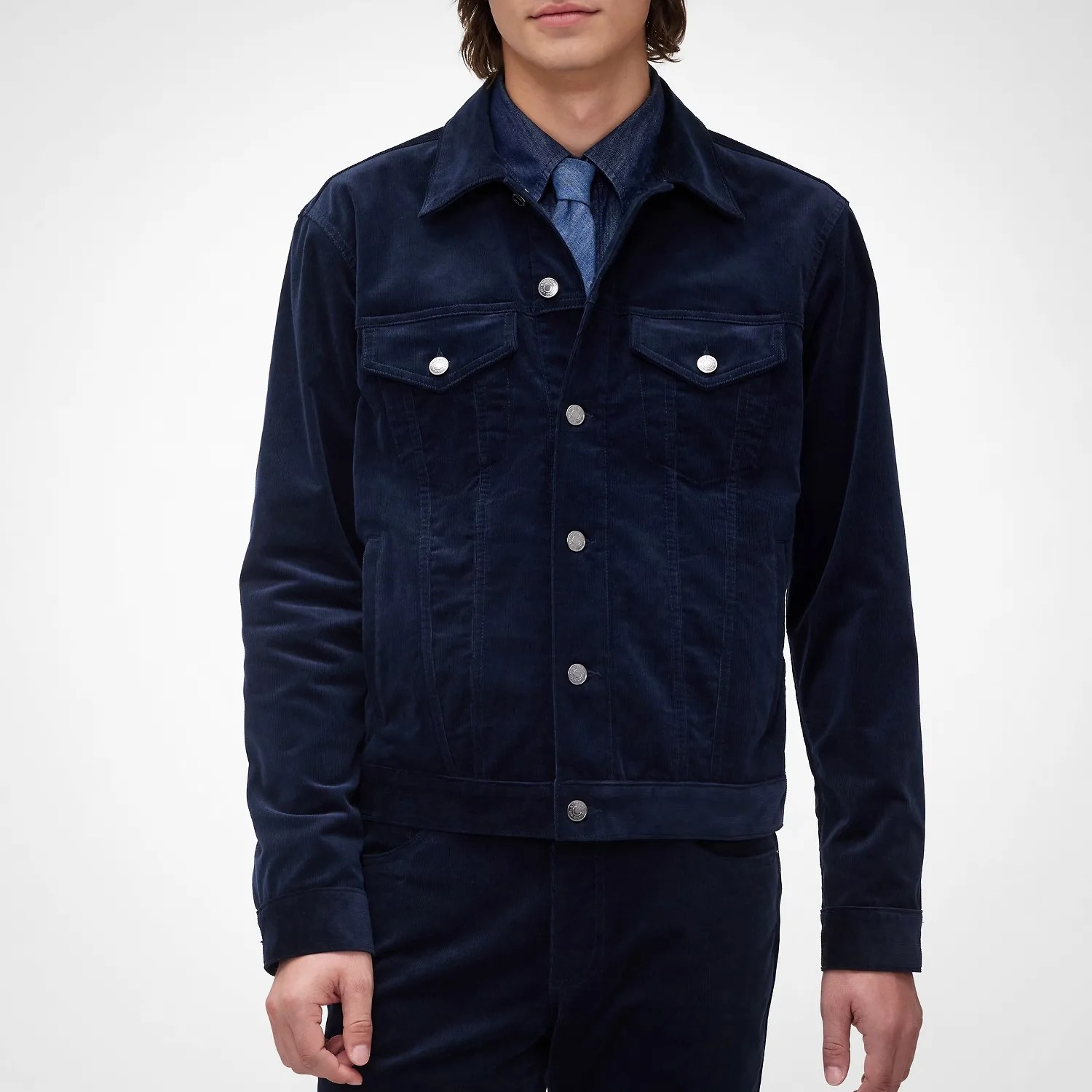 Navy blue corduroy jacket with silver buttons worn over a matching shirt and tie.