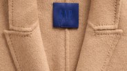 Close-up of a camel-colored wool coat collar with a blue GAP Studio label.