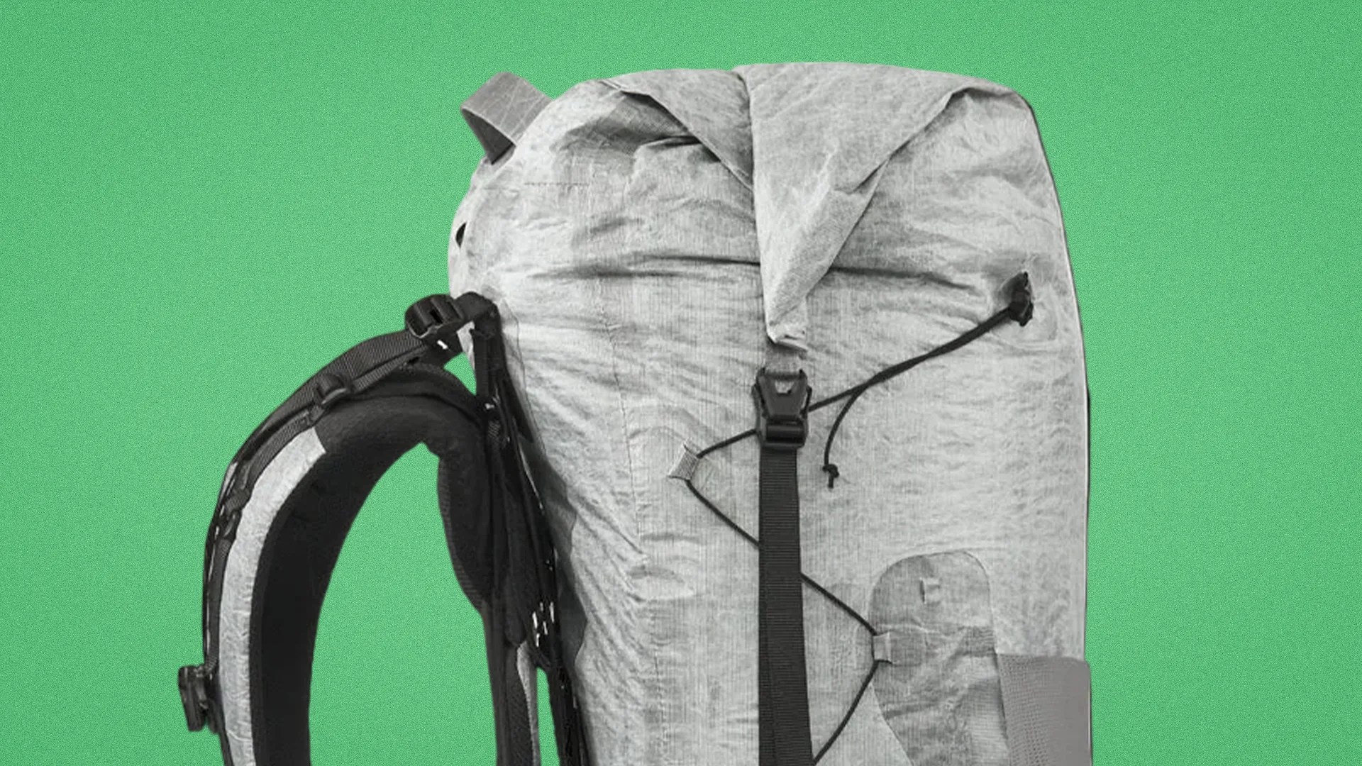 Light gray roll-top backpack with black adjustable strap and padded shoulder harness against a green background.