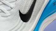 Close-up of a white Nike sneaker with a black swoosh logo and a blue air-cushioned sole.