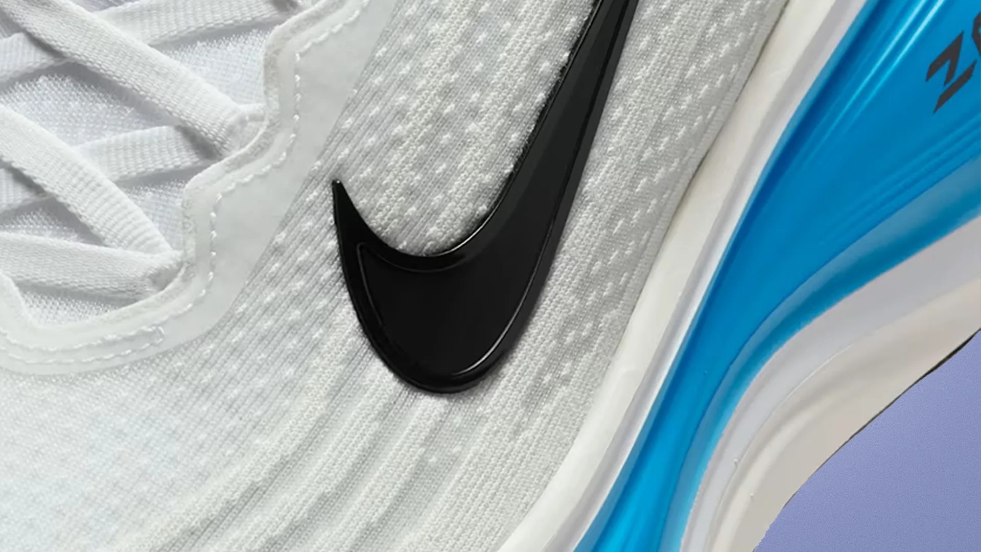 Close-up of a white Nike sneaker with a black swoosh logo and a blue air-cushioned sole.
