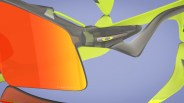 Close-up of Oakley sports sunglasses with orange Prizm lenses and neon yellow and gray frame.