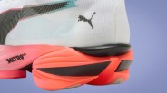 Close-up of a white Puma sneaker with a bright coral Nitro Lite sole and black accents.