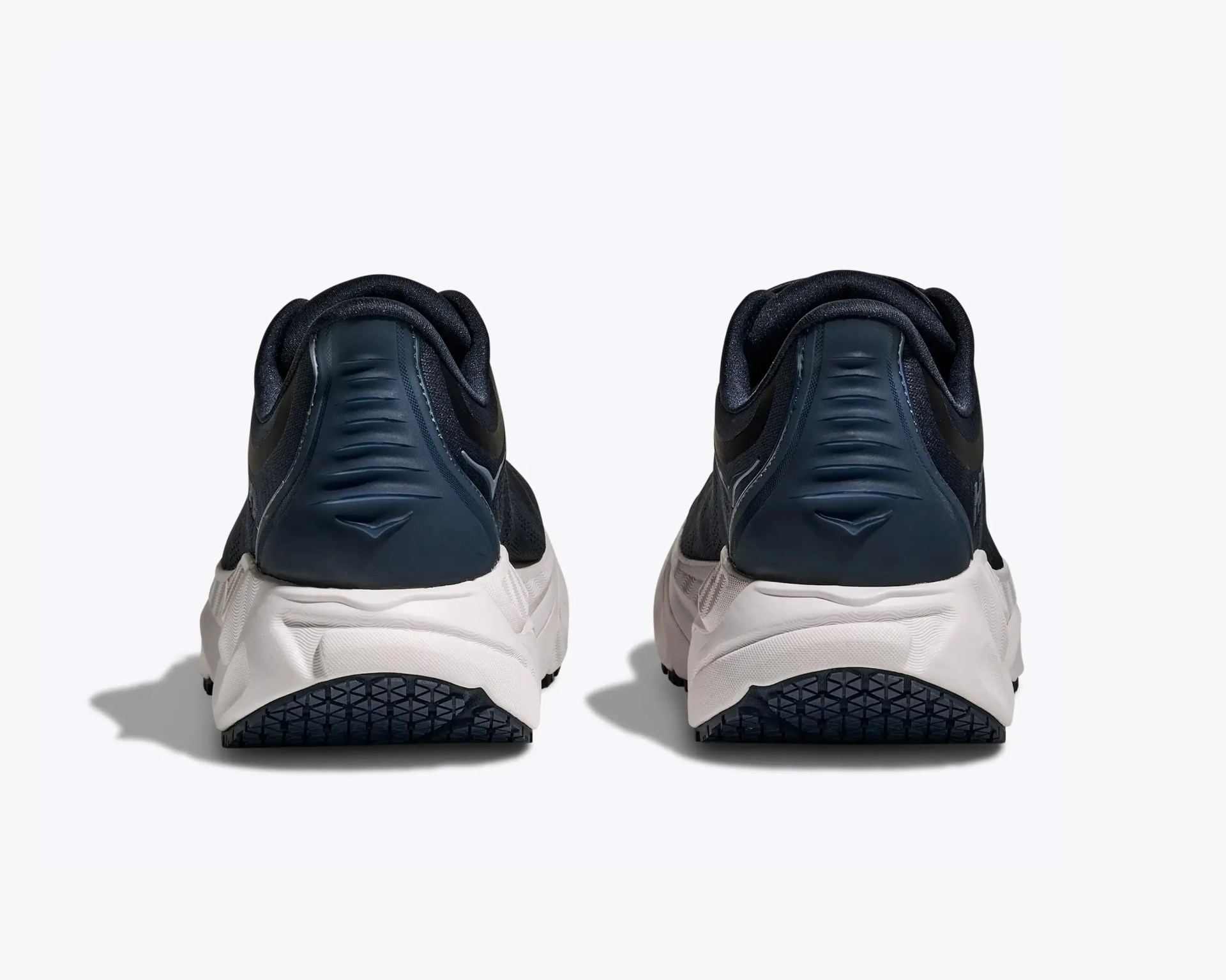 Pair of black and white athletic shoes shown from the back on a white background.