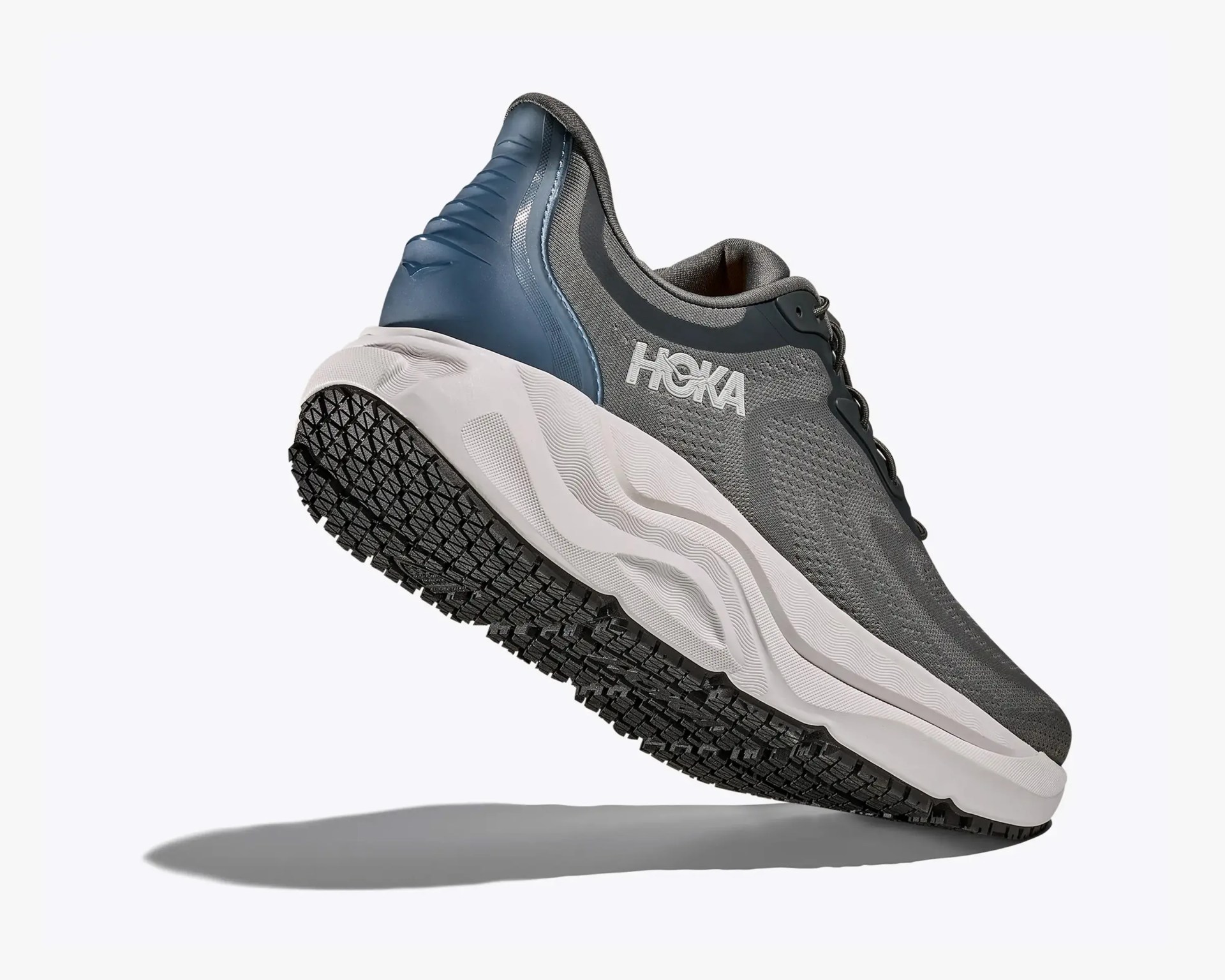 Gray and navy Hoka running shoe with white midsole and black textured outsole, angled to show side and bottom.