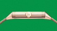 Side view of a rose gold wristwatch case with a ridged crown and linked bracelet against a green background.
