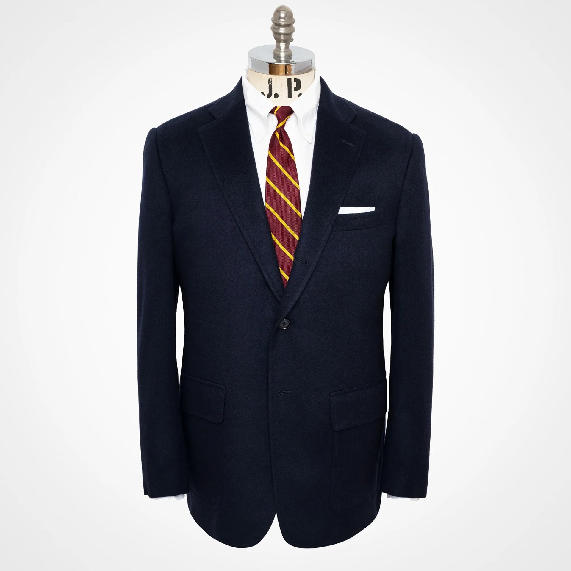 Navy blazer with notch lapels, white dress shirt, and maroon striped tie on a mannequin.