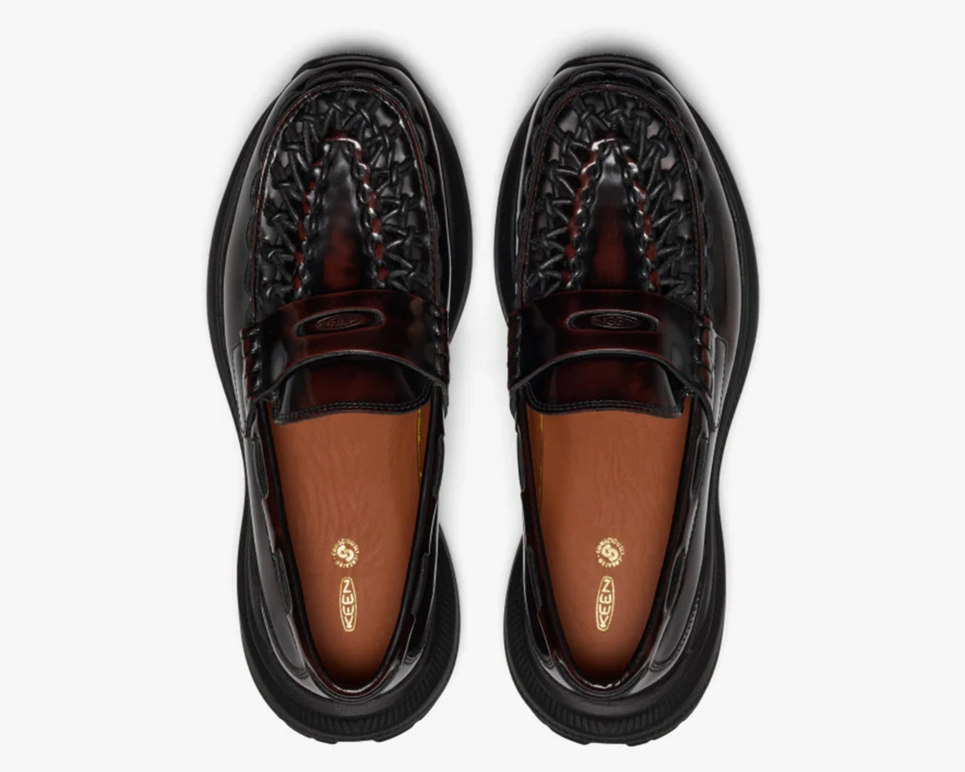 Pair of black woven leather slip-on shoes with brown insoles and black rubber soles.