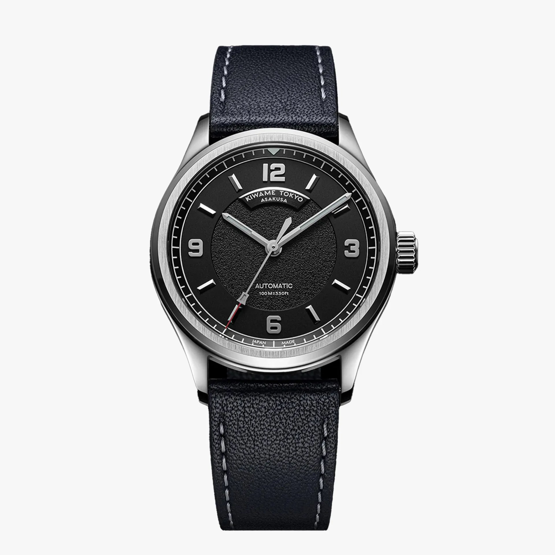 Black dial automatic wristwatch with silver markers and black leather strap with white stitching.
