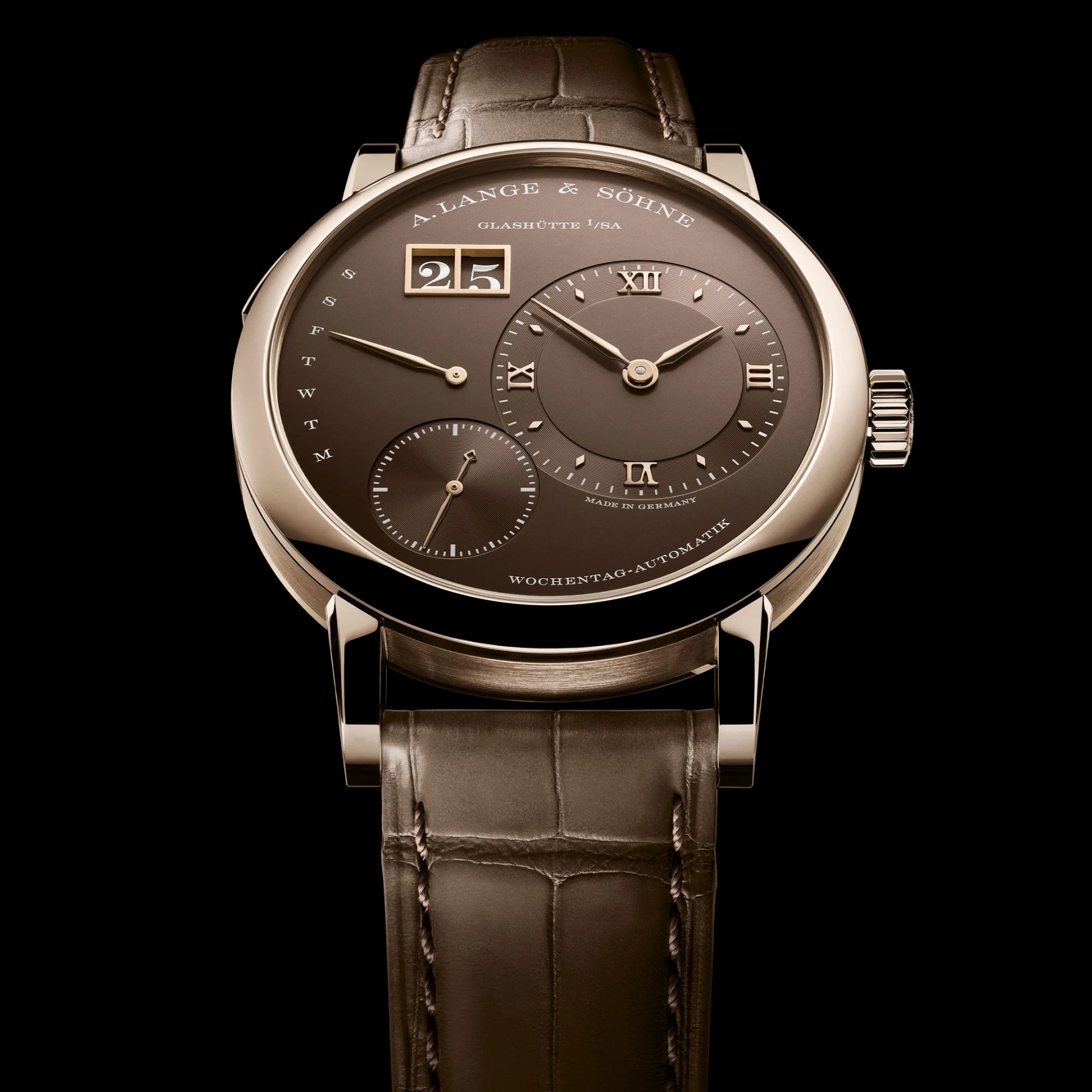 Brown dial A. Lange & S&ouml;hne wristwatch with gold case, Roman numerals, date window, day indicator, and brown leather strap.
