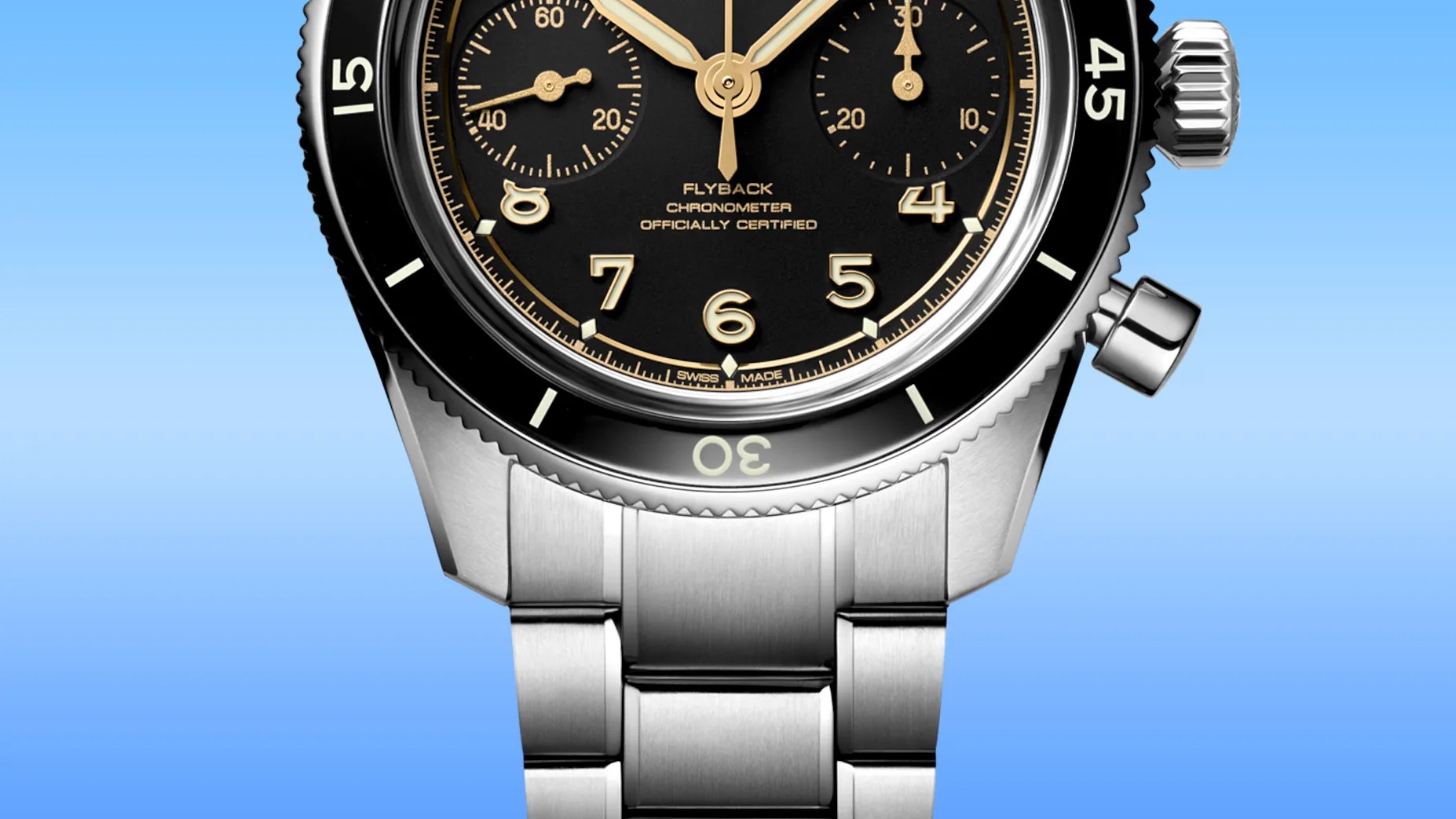 Close-up of a stainless steel wristwatch with a black dial, gold numerals, and a black bezel against a blue background.