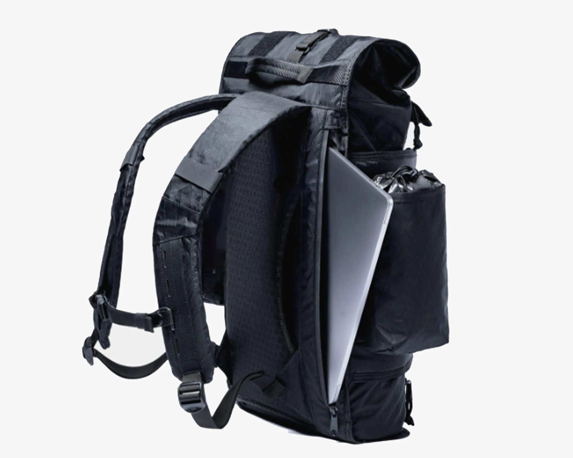 Black tactical backpack with padded straps and a laptop partially inserted in a side compartment.