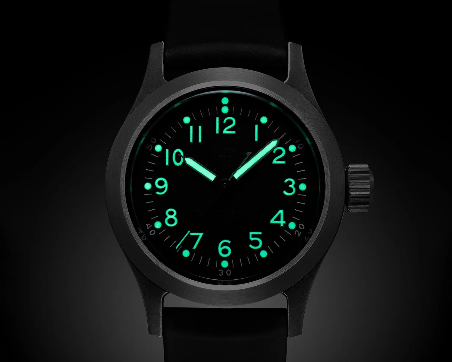 Black wristwatch with glowing green numerals and hands on a dark background.