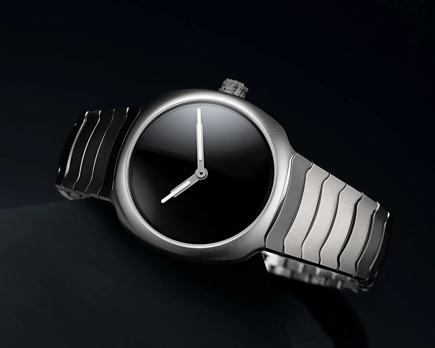 Silver metal wristwatch with a black reflective dial and silver hour and minute hands on a dark background.