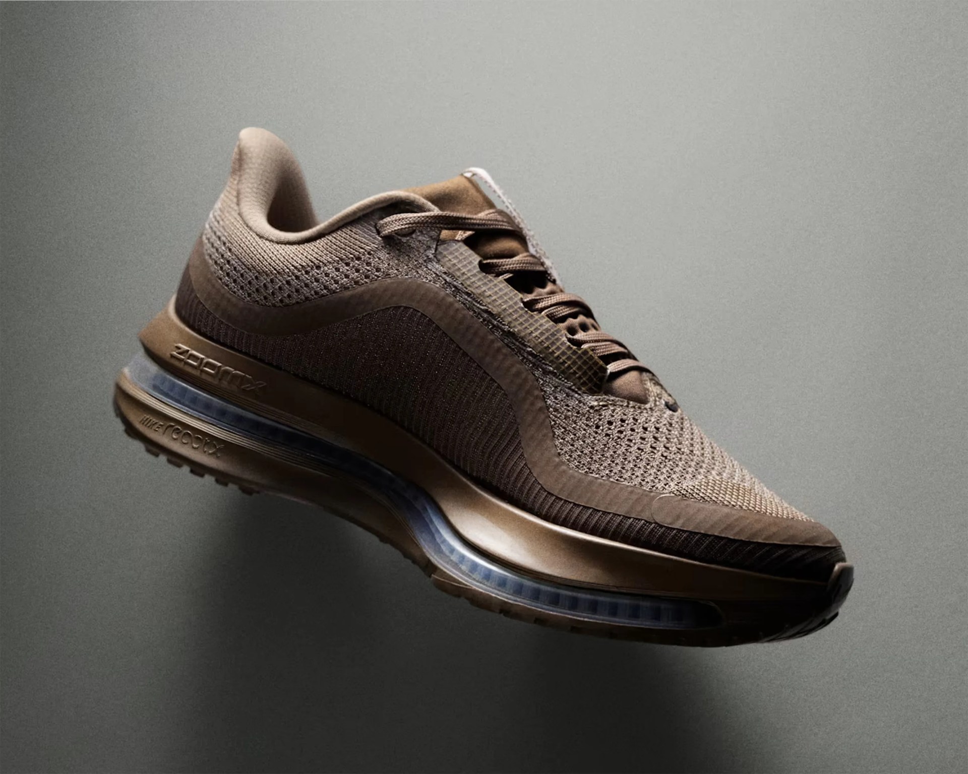 Brown Nike Air Max sneaker with mesh upper and visible air cushioning in the sole against a gray background.