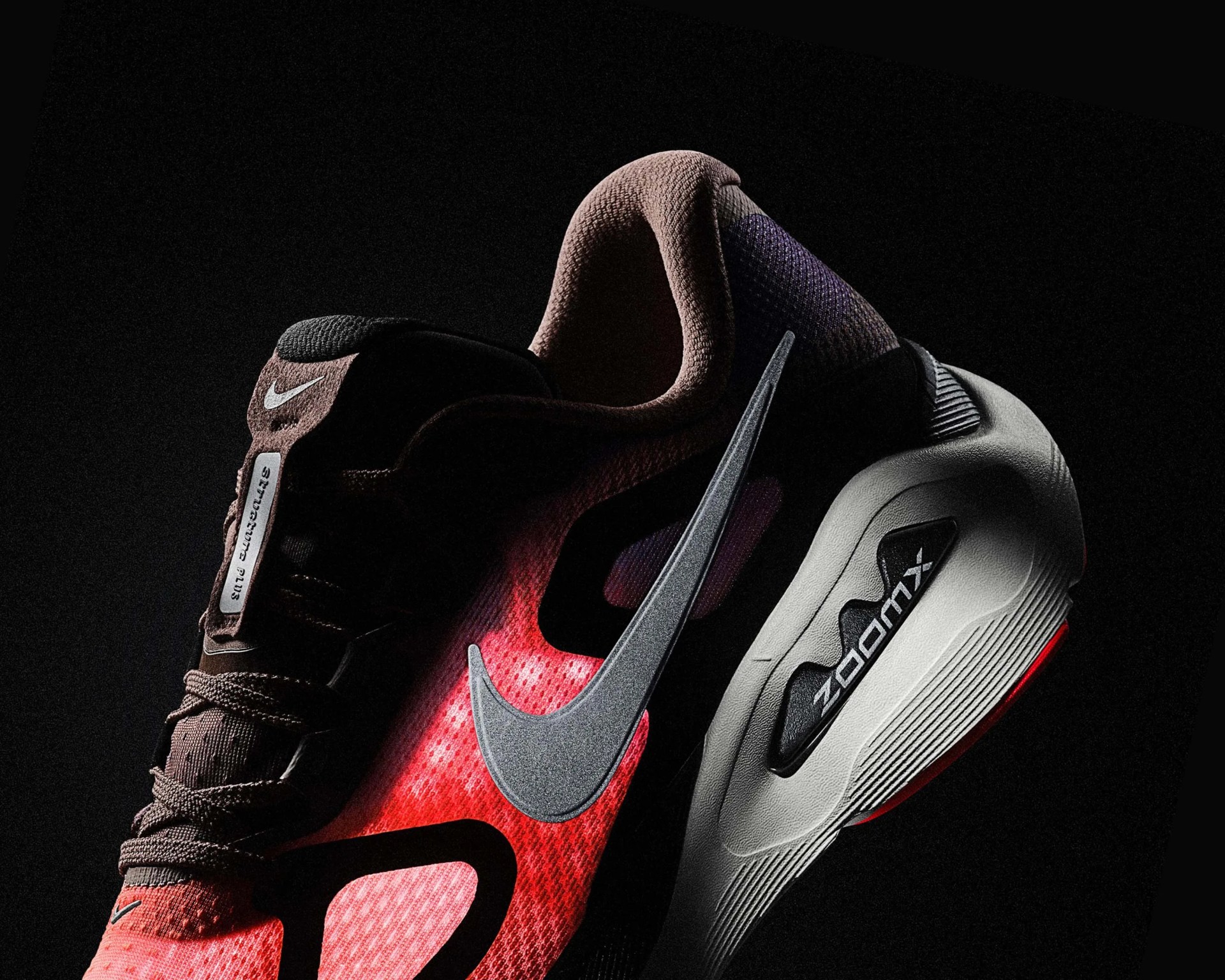 Nike ZoomX running shoe in red and black with a large silver swoosh and white sole.