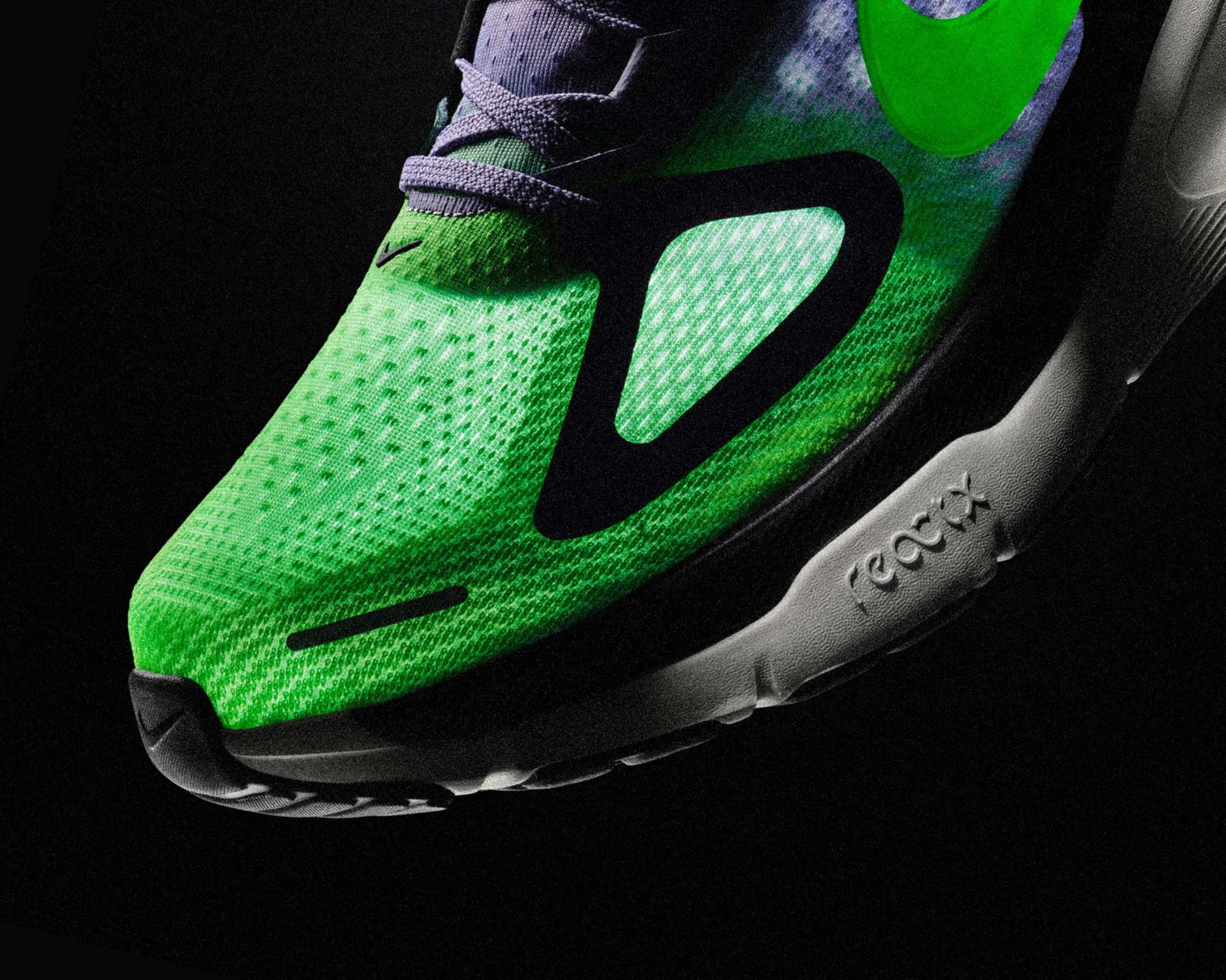 Close-up of a green and black Nike React running shoe with a white sole on a black background.