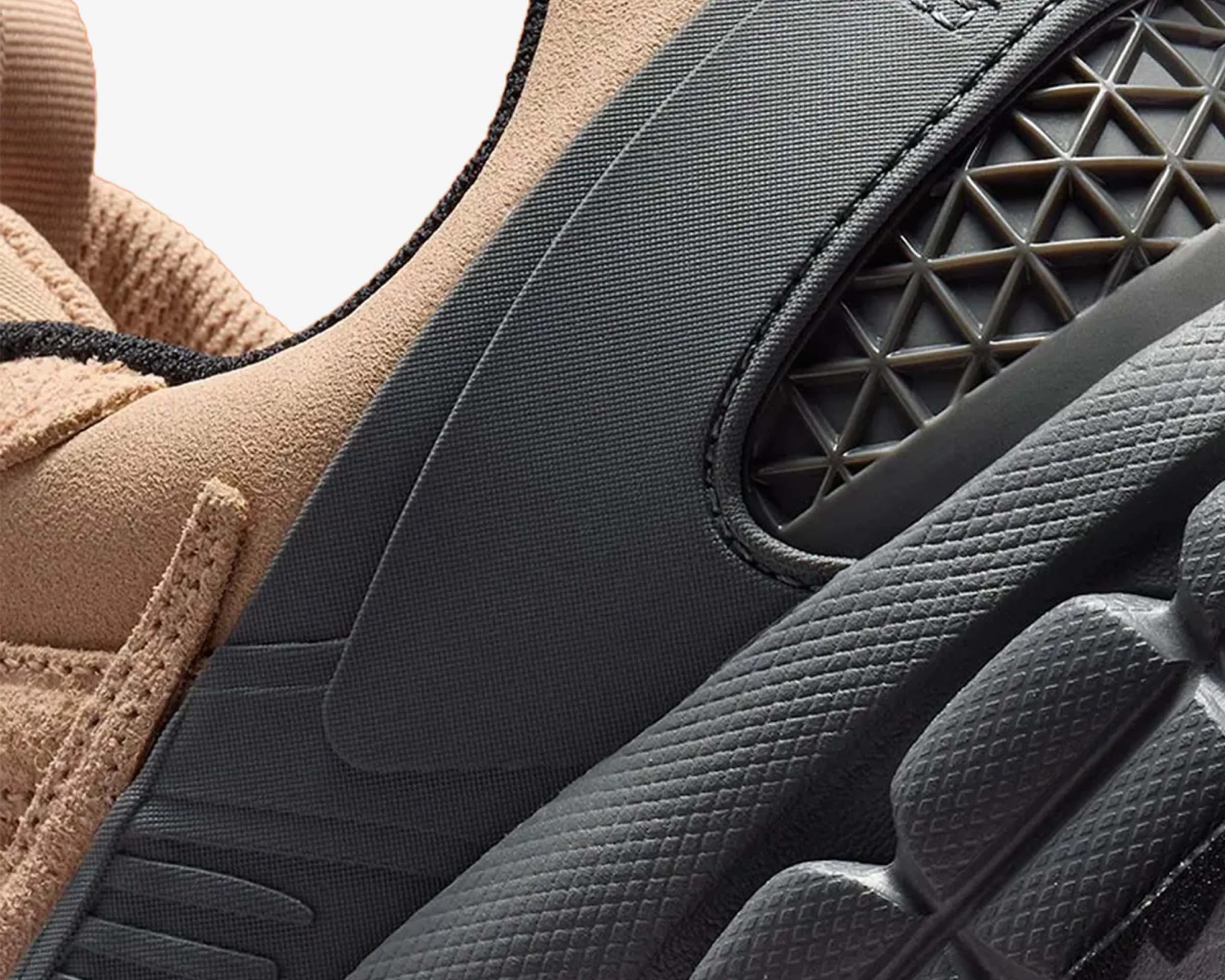 Close-up of a beige suede sneaker with black textured rubber sole and geometric pattern detail.