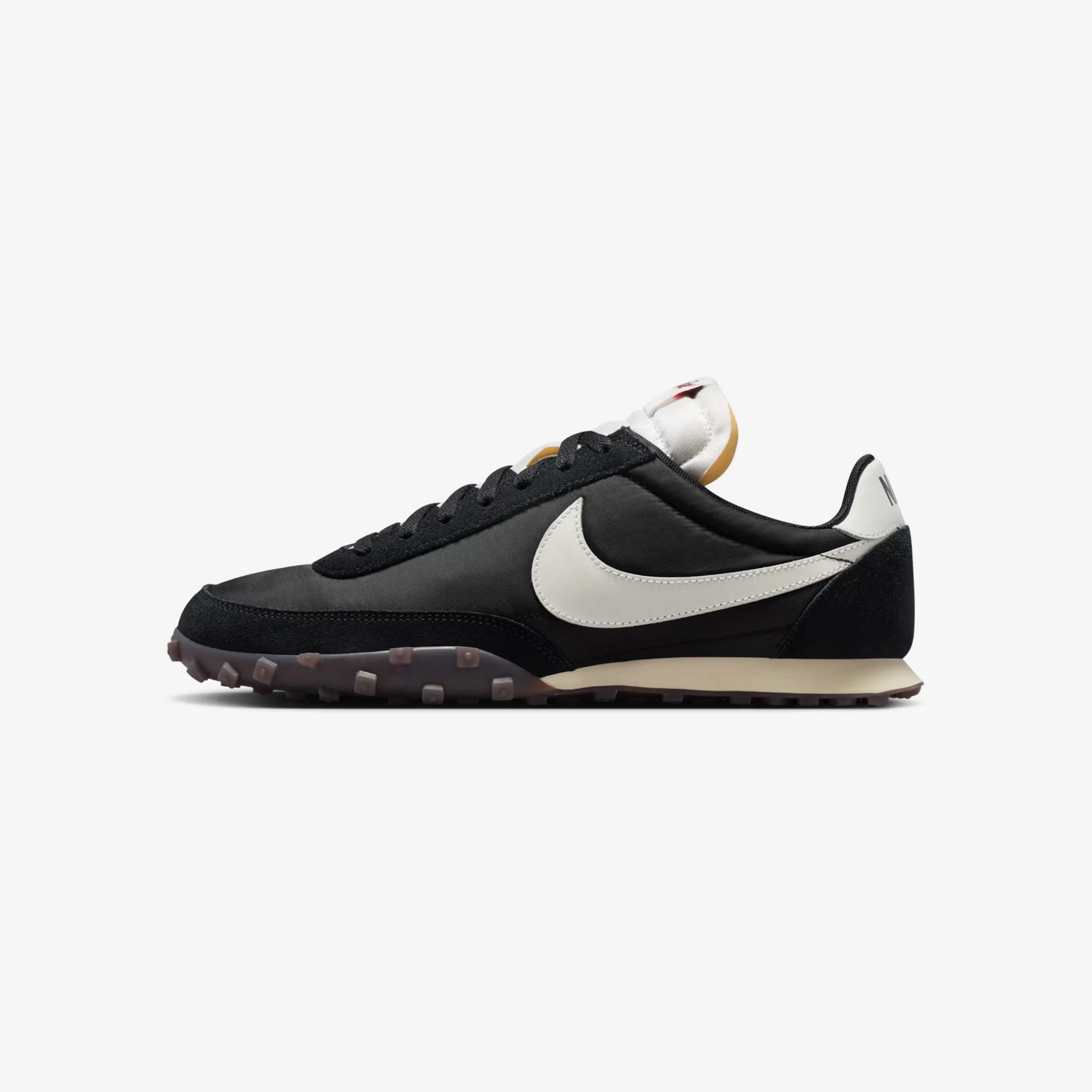 Black and white Nike sneaker with a white swoosh and gum sole, shown from the side.