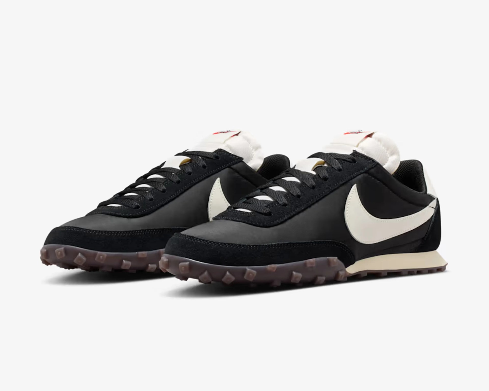 Pair of black and white Nike sneakers with textured brown soles on a white background.