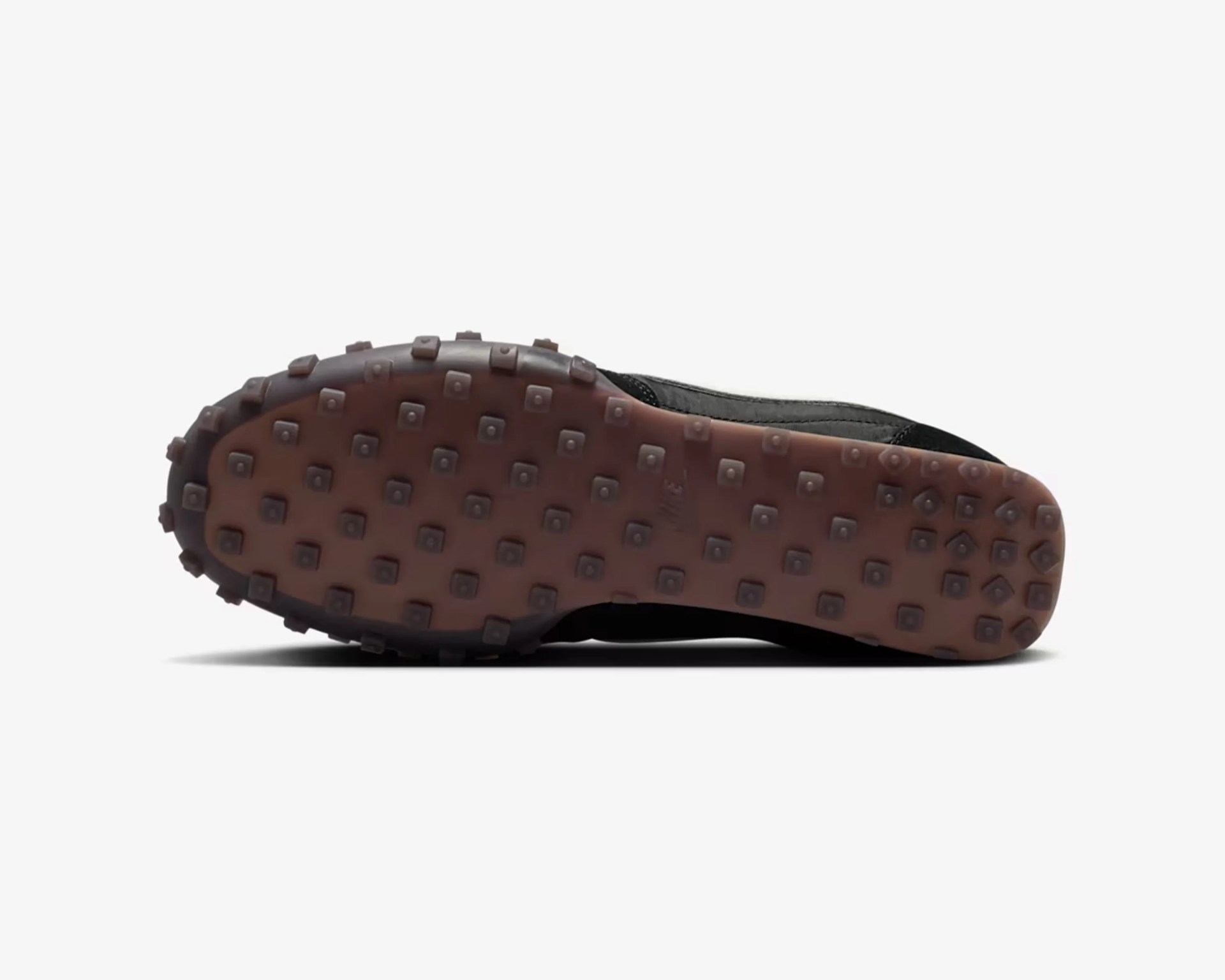 Shoe sole with brown rubber outsole featuring square-shaped lugs for traction.