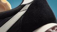 Close-up of black and white sneaker heel with textured black suede and white leather accents.