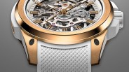 Close-up of a skeleton watch with a rose gold bezel and white textured rubber strap.