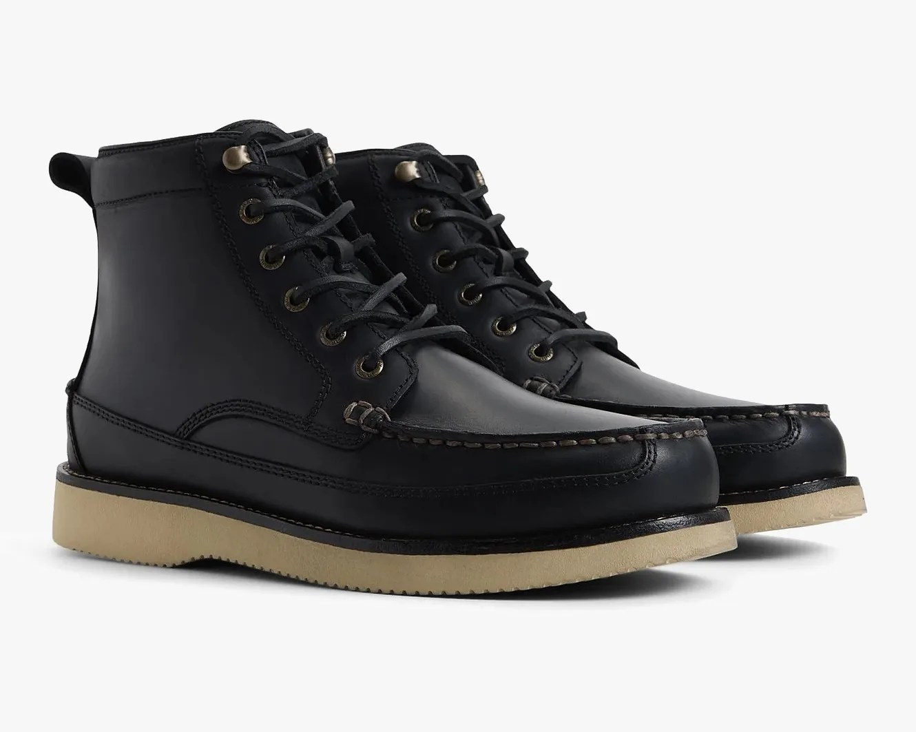 Pair of black leather moc toe boots with beige rubber soles on a white background.