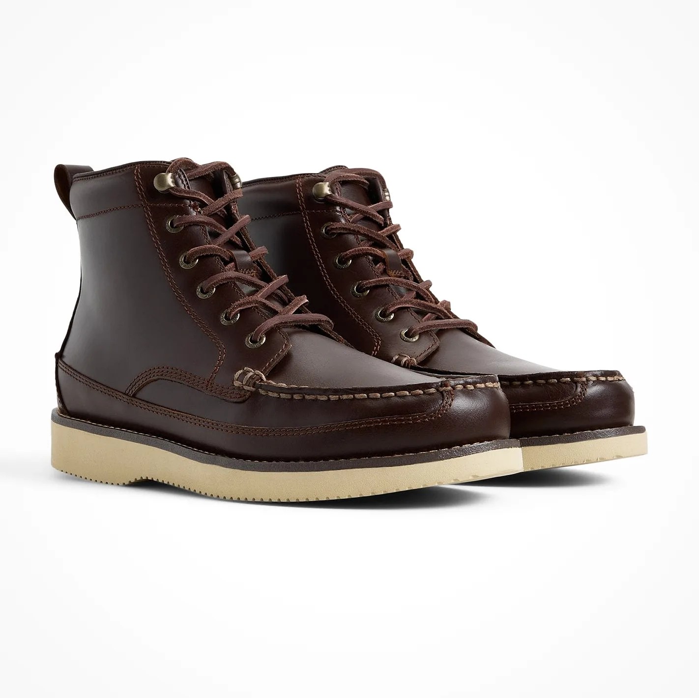 Pair of dark brown leather moc toe boots with beige rubber soles on a white background.