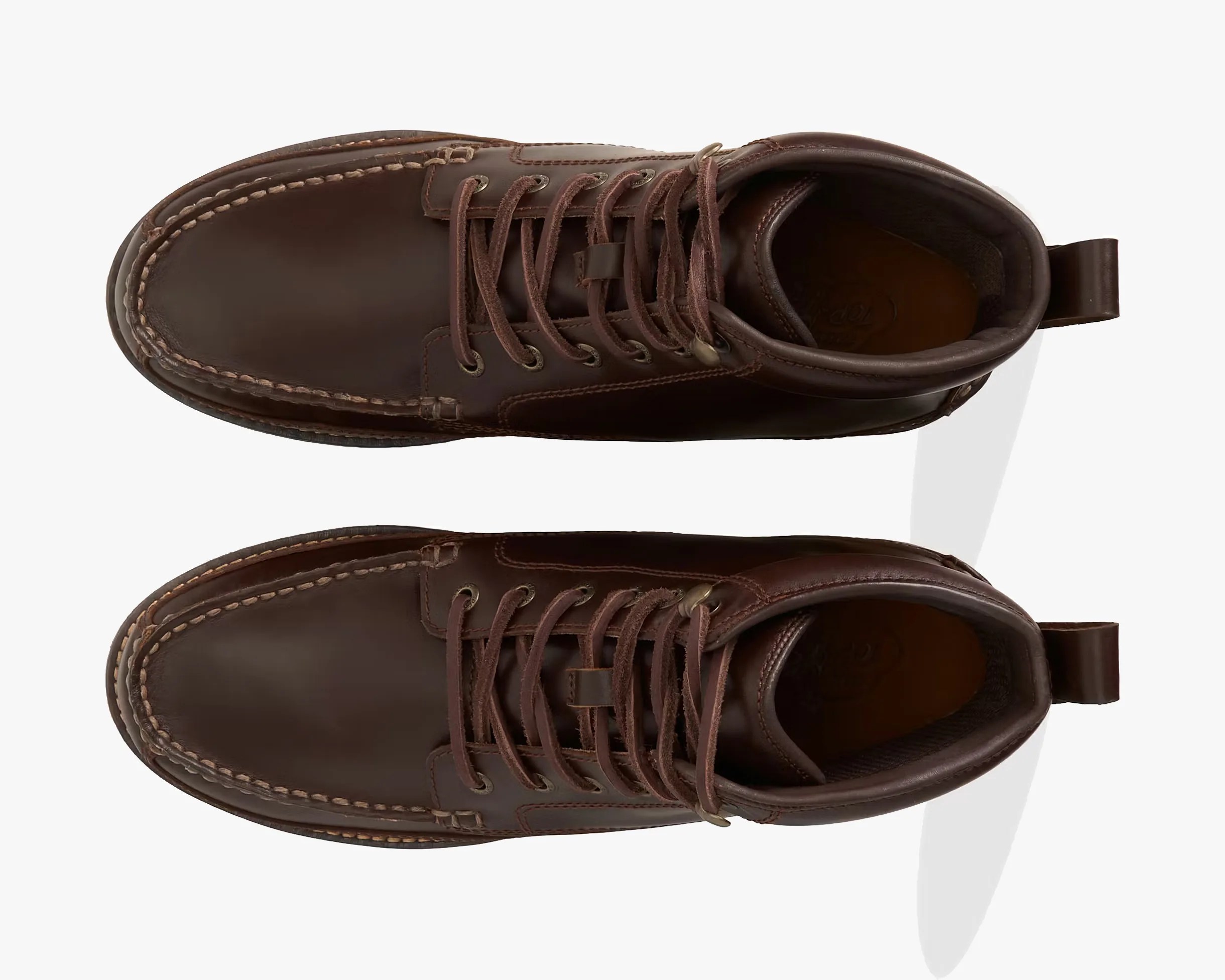 Pair of dark brown leather moc toe boots with brown laces viewed from above.