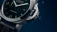 Close-up of a Panerai Luminor Marina watch with a black dial, luminous hands, date display, and a stainless steel case with crown guard.