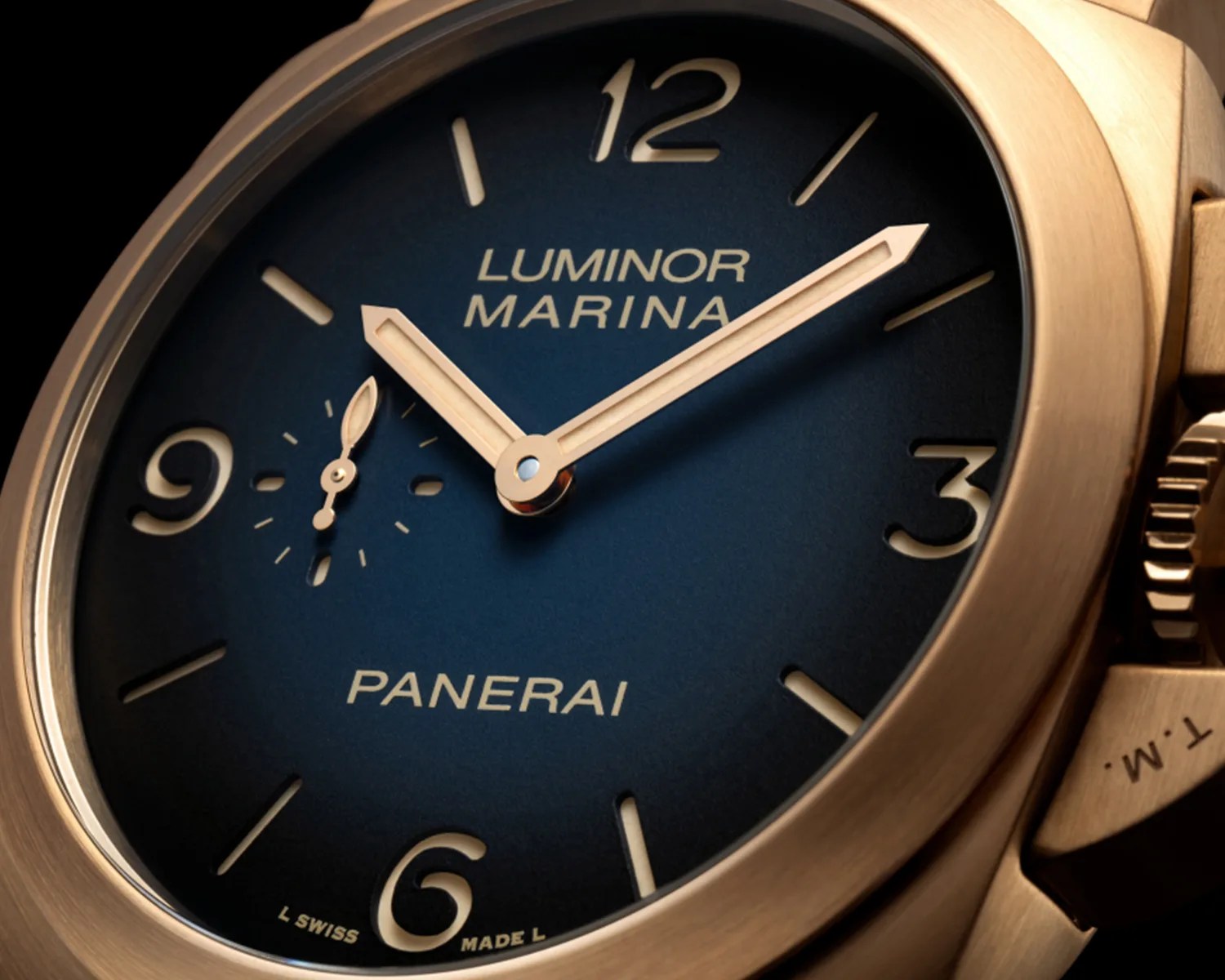 Close-up of a Panerai Luminor Marina watch with a blue dial and gold-tone case and hands.