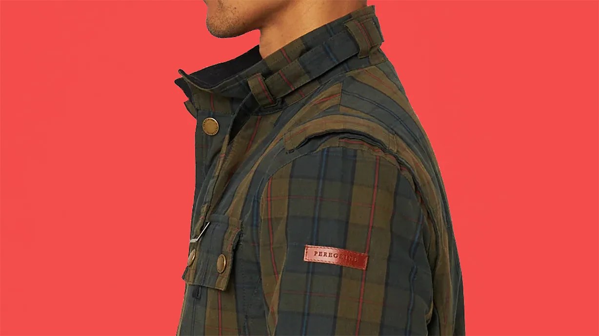 Green and navy plaid jacket with brown leather "Peregrine" patch on the sleeve against a red background.