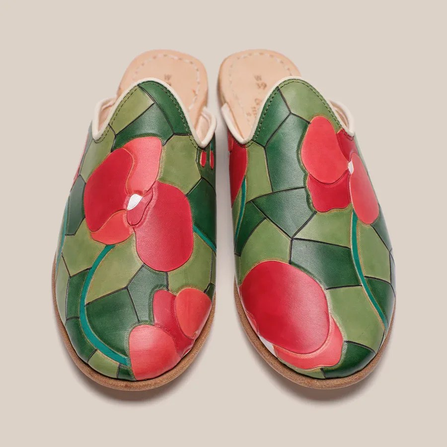 Pair of slip-on leather shoes with green and red floral mosaic pattern on top.