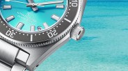Close-up of a stainless steel diver's watch with a turquoise dial and black bezel showing "AUTOMATIC 3 DAYS DIVER'S 300m.