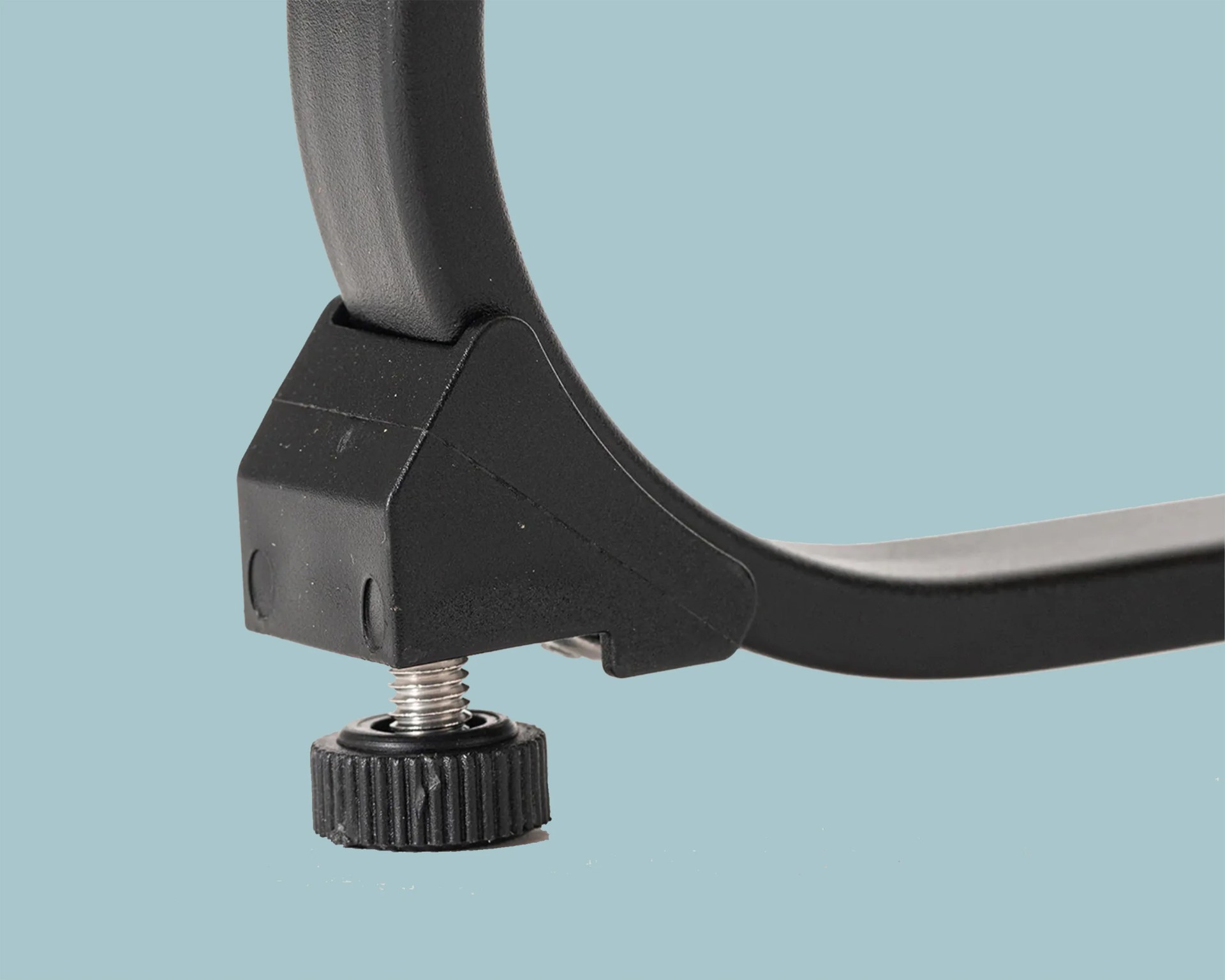 Close-up of a black metal frame leg with an adjustable threaded foot on a light blue background.