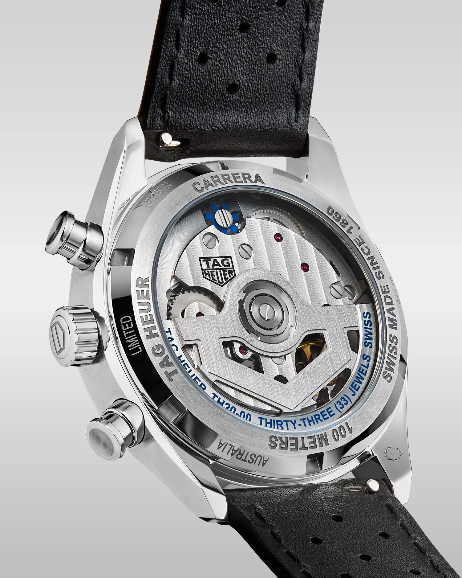 Back view of a TAG Heuer Carrera watch with visible mechanical movement and black perforated leather strap.