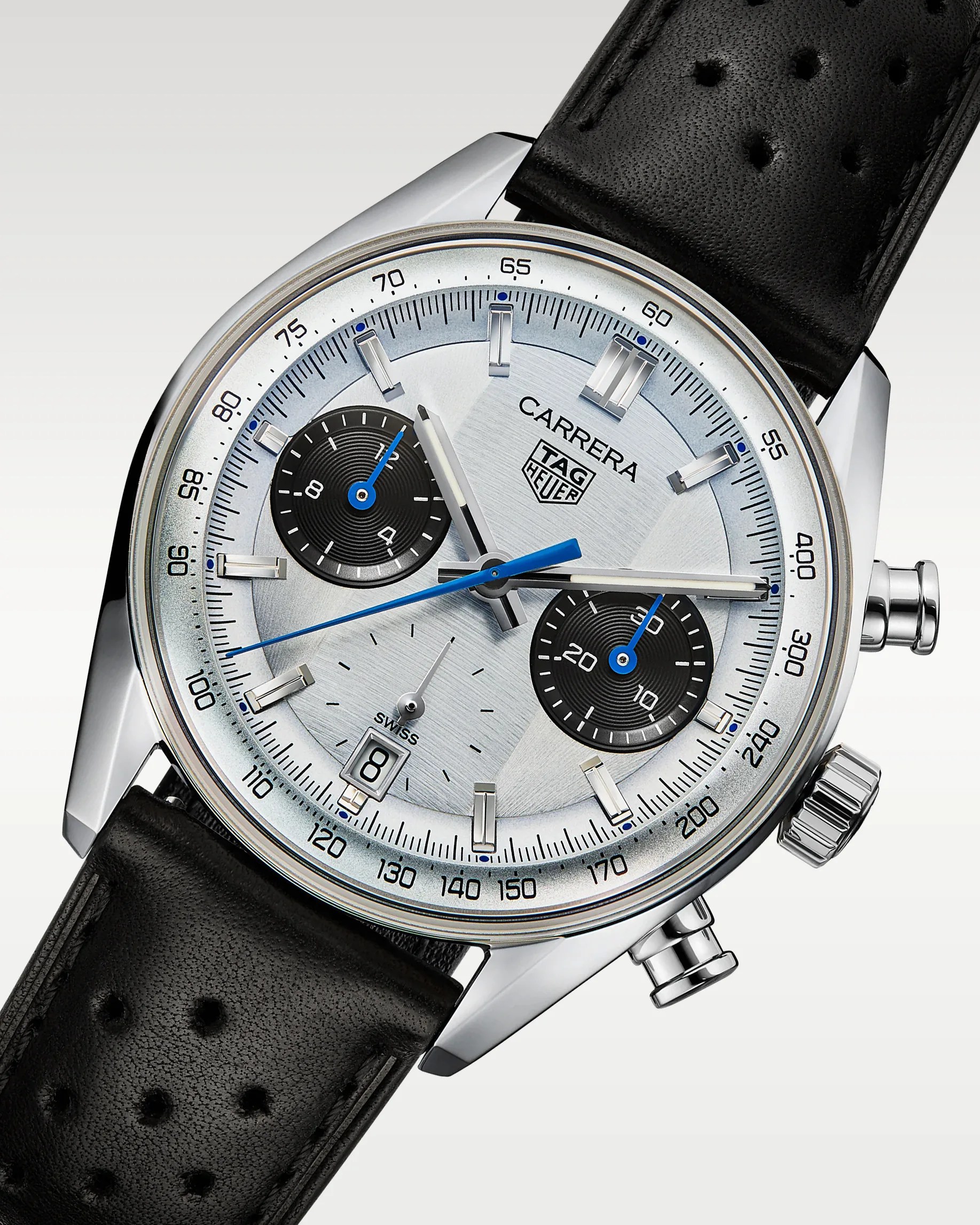 Silver TAG Heuer Carrera chronograph watch with black perforated leather strap and blue hands.