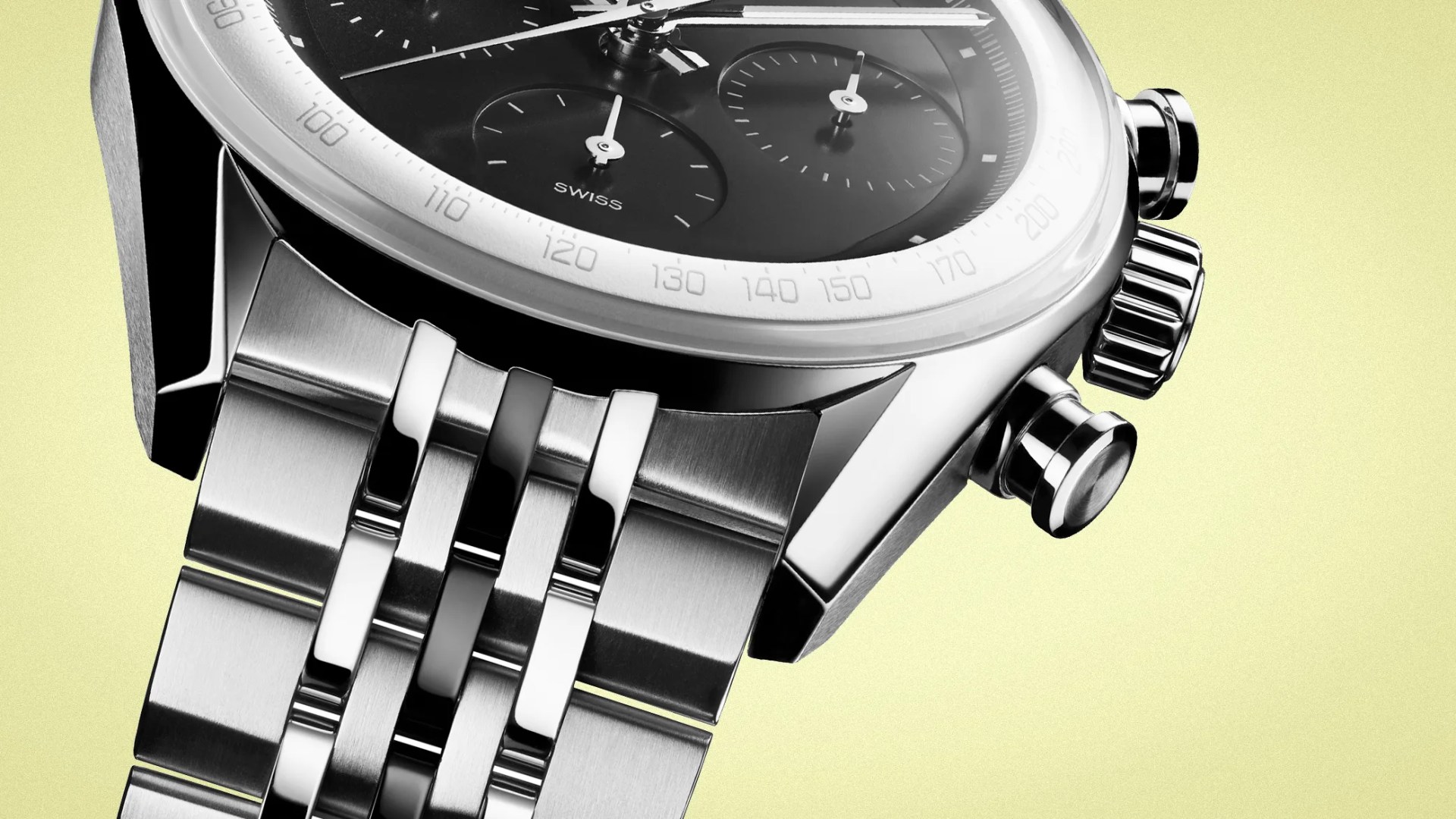 Close-up of a stainless steel chronograph watch with a black dial and metal bracelet against a light yellow background.