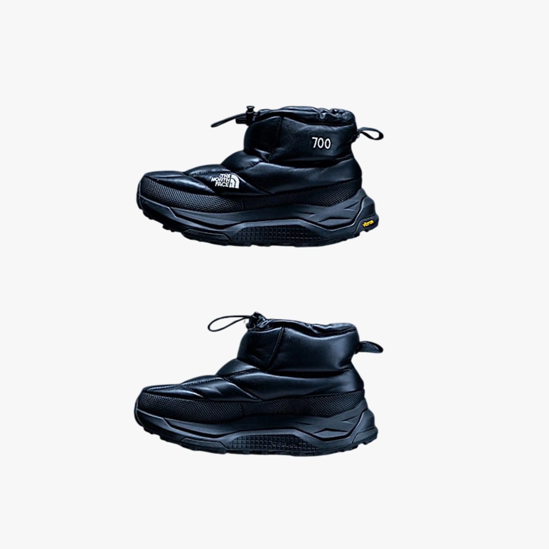 Pair of black insulated winter boots with thick soles, one showing The North Face logo and "700" text.